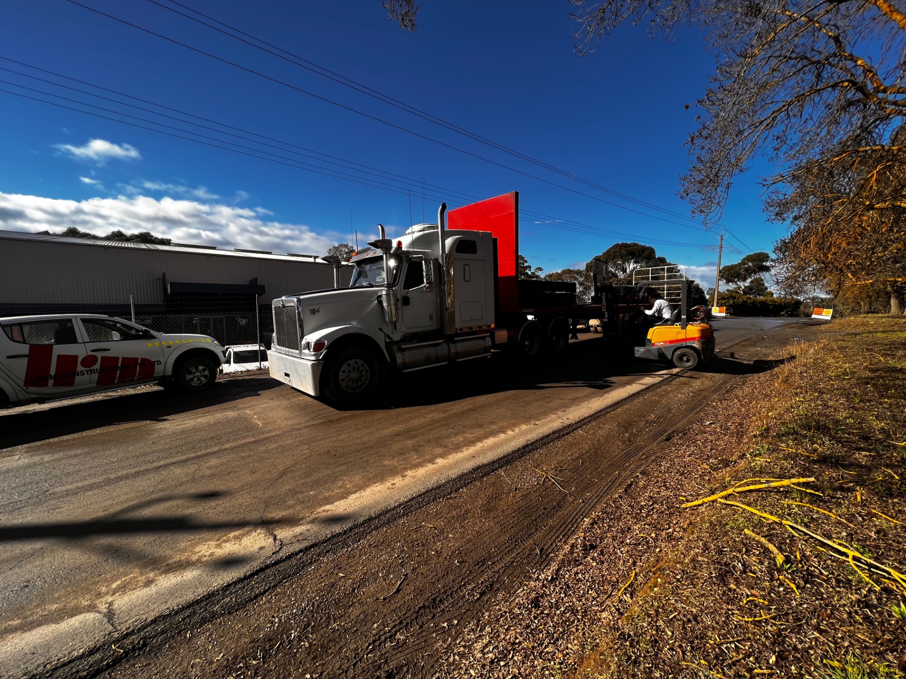Prime mover with flatbed trailer being loaded with star droppers
